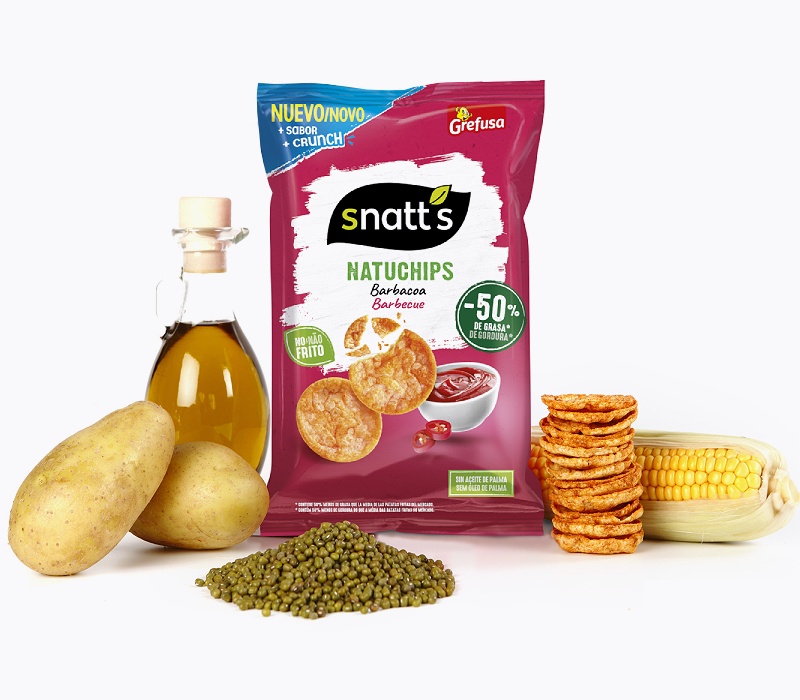 bodegón de bolsas de snacks Snatt’s con ingredientes naturales (maíz, ajo, etc.)